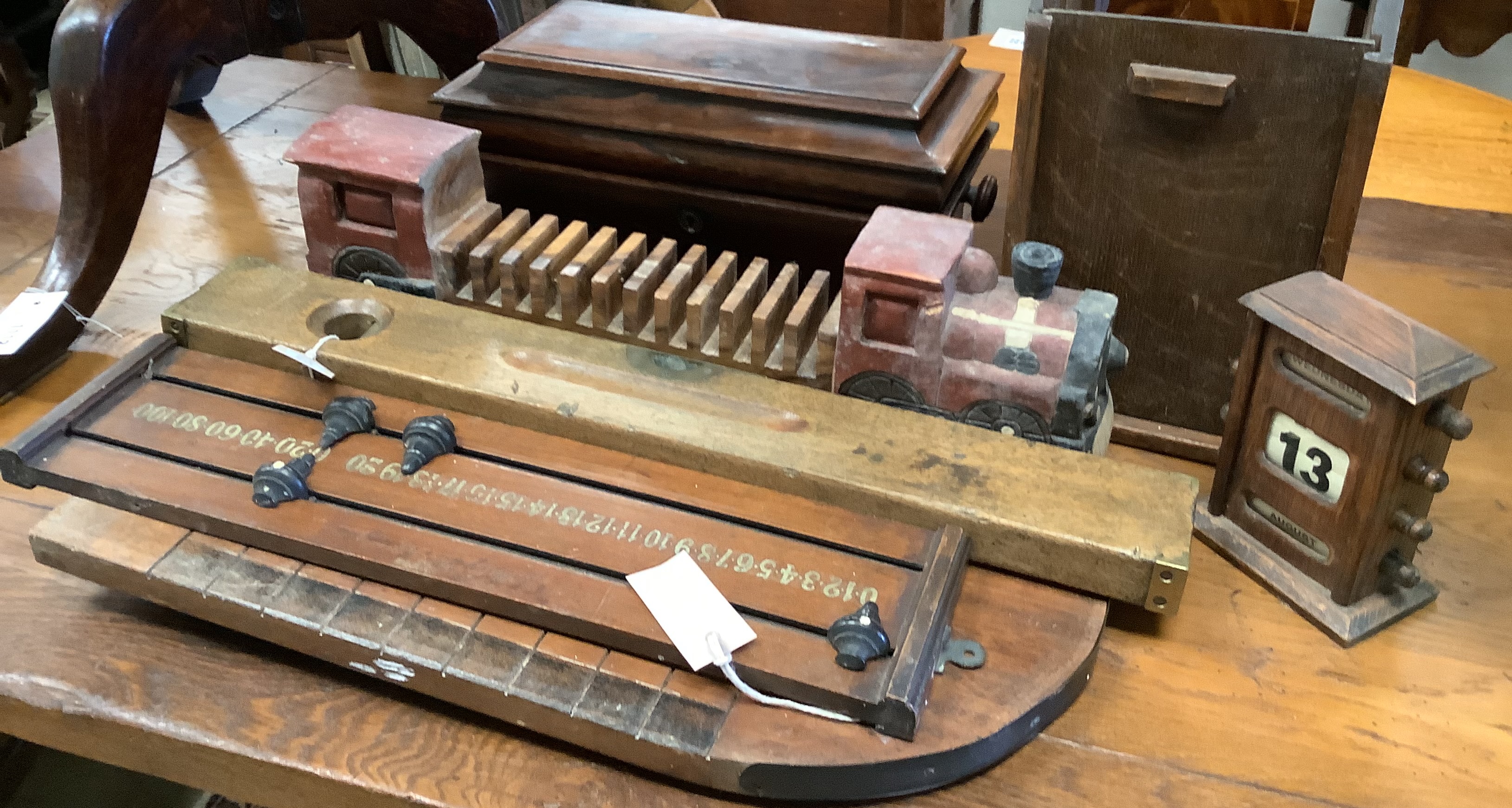 A Shove Ha'penny board, a Preston & Sons brass-mounted spirit level, a Riley's billiards scoreboard and a tea caddy